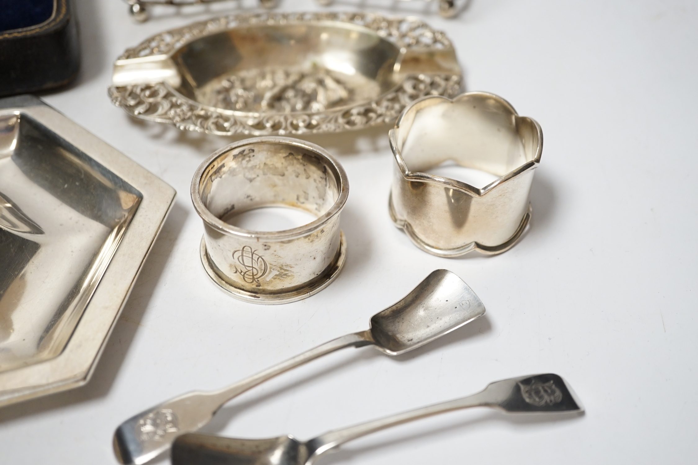 A Dutch white metal ashtray, with pierced border, 13.1cm and one other silver hexagonal ashtray?, a pair of small silver toastracks, two silver napkin rings and six items of silver flatware, including pair of Irish condi